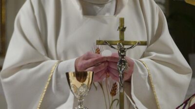 padre na santa missa consagrando pão e vinho eucaristia cruz de jesus