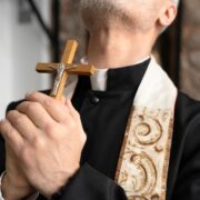 padre exorcista segurando crucifixo