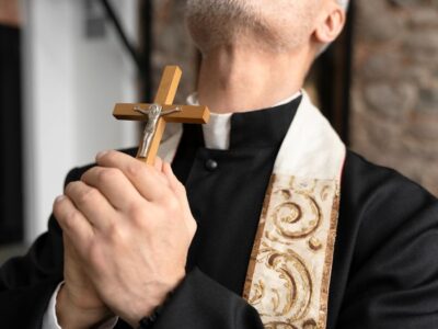 padre exorcista segurando crucifixo