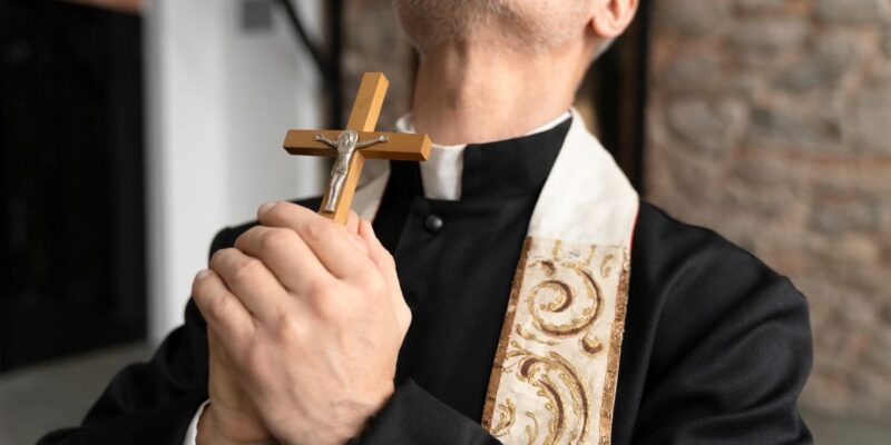 padre exorcista segurando crucifixo